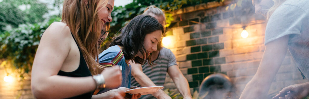 A group of friends cooking a meal together outdoors