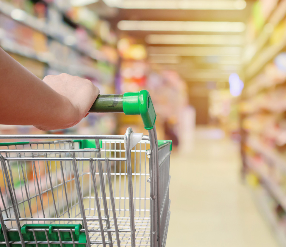 A grocery shopper pushing a cart down an aisle