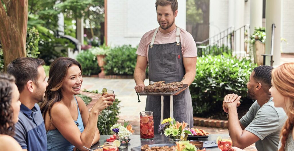 A group of friends eating steak outdoors 