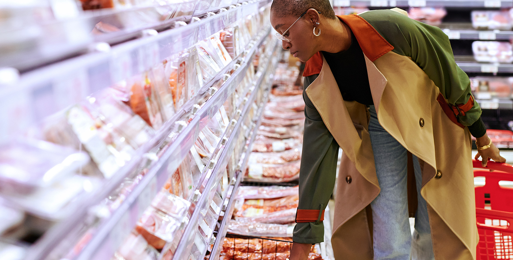 Woman examining a package of pork in a grocery store