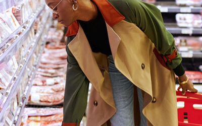 Woman examining a package of pork in a grocery store