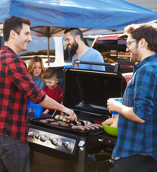 Tailgating at a sporting event, cooking on a portable grill