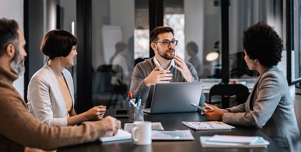 Marketing experts seated at a table discussing brand strategies
