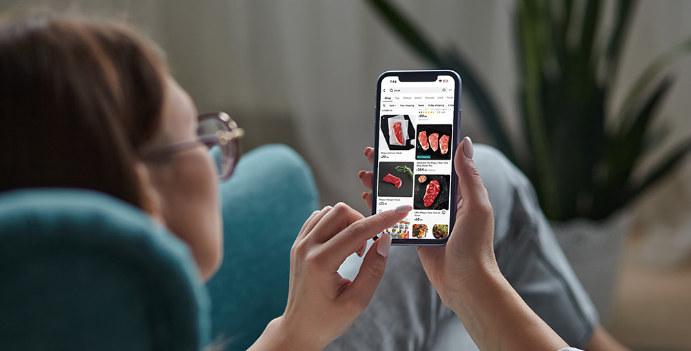 Person holding phone in hand looking at the TikTok shop