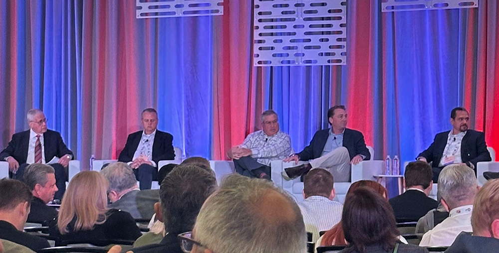 Four men speaking at the MICA Conference