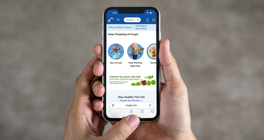 Hands holding a cell phone displaying a mobile ad