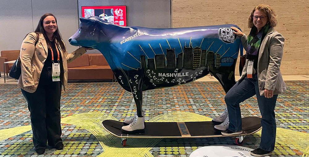 Midan teammates standing beside a statue of a cow wearing shoes standing on a skateboard