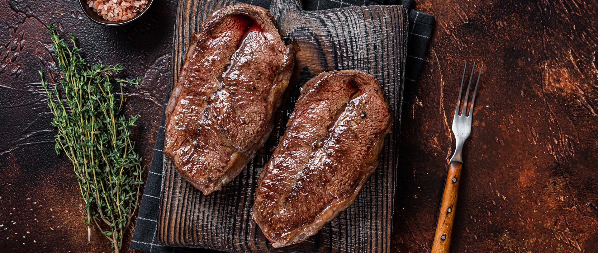 Two steaks cooked and prepared on a cutting board